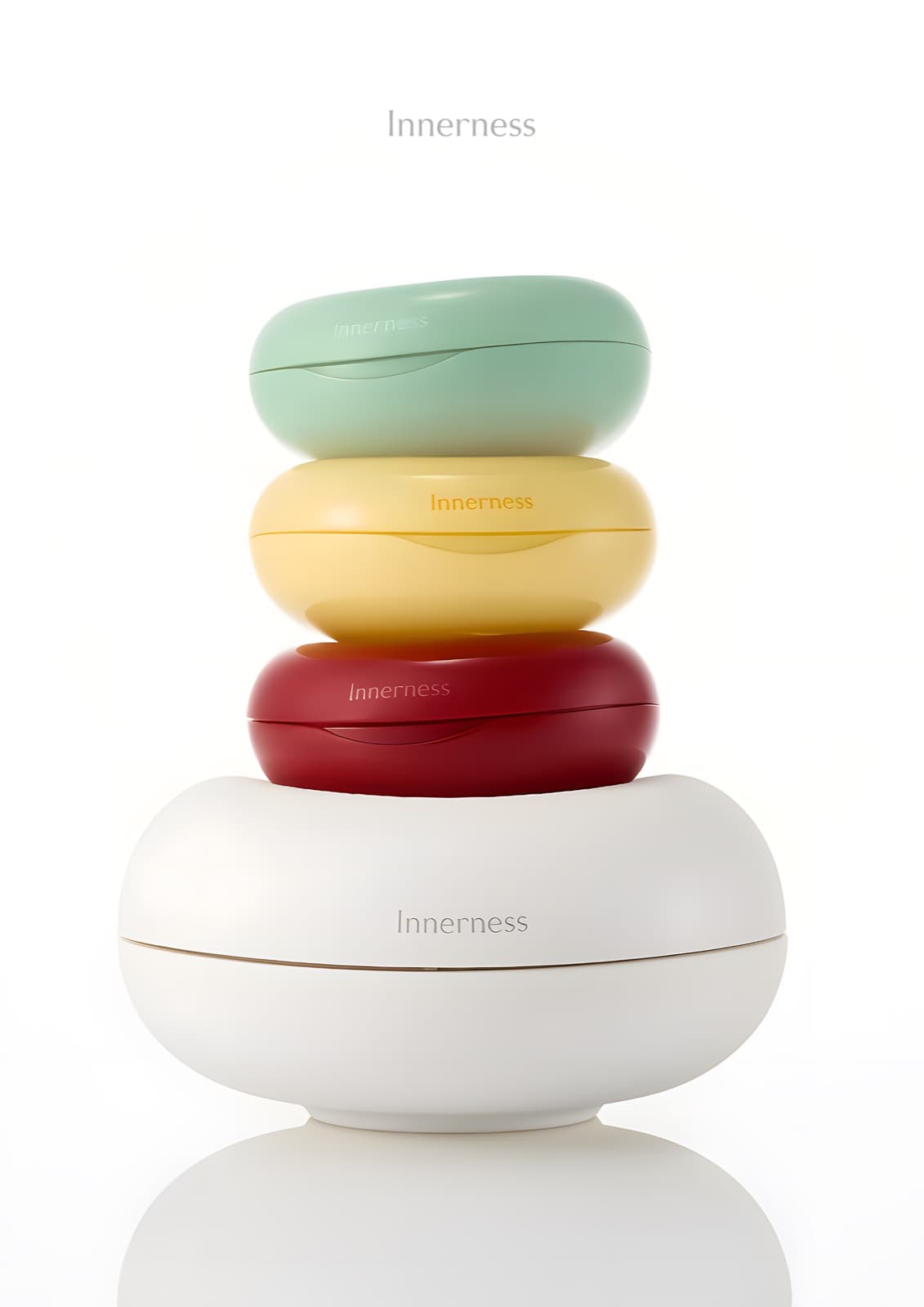 Innerness supplement containers in mint, yellow, red, and white, stacked like smooth pebbles